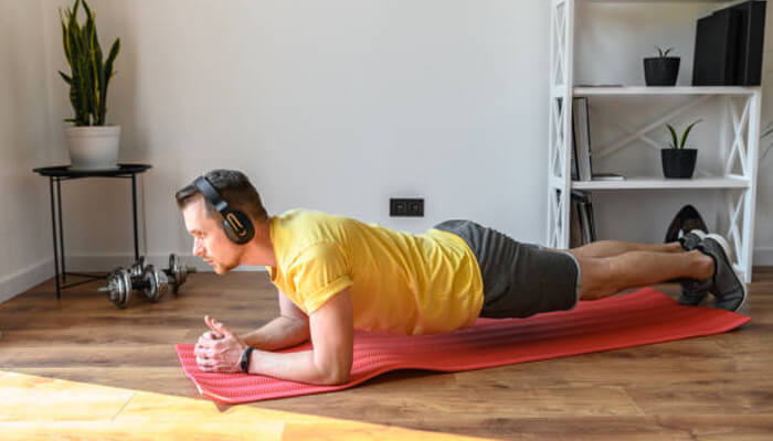 Daily balance practice | tycoonstory media Man doing plank exercises to build balance and core strength to prevent trip and fall injuries at home