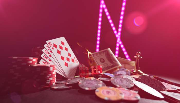 What you can actually do with free credits | tycoonstory media Casino table with poker chips, playing cards, and scattered cash under pink neon lights in a casino setting.