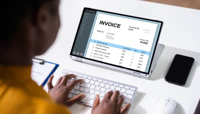 Who should use factoring 1 1 | tycoonstory media Business owner reviewing invoices and understanding the advantages and disadvantages of factoring for cash flow management