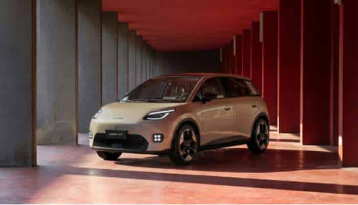 Best chinese electric cars in europe 2026 10 | tycoonstory media Cream-colored suv parked in a red-lit, column-lined corridor with a polished floor.