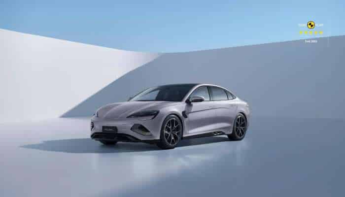 Best chinese electric cars in europe 2026 6 | tycoonstory media Three-quarter front view of a silver sedan in a bright, minimalist blue studio setting.