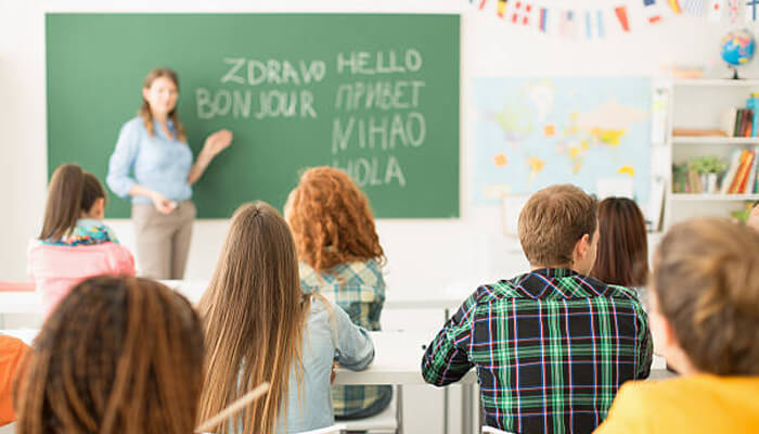 Immersive language schools | tycoonstory media Students in a classroom practicing multiple languages, highlighting the benefits of learning spanish through interactive and immersive language education.