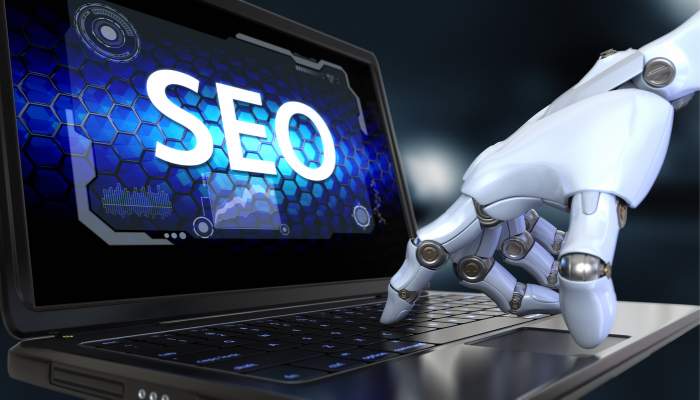 Bloom agency expands ai-driven digital solutions to help businesses thrive in an evolving online marketplace 1 | tycoonstory media Robot hand typing on a laptop displaying the word seo with a futuristic blue interface.
