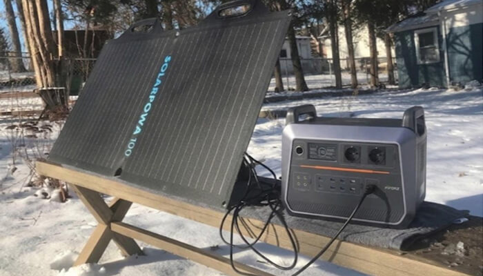 What is best battery for solar system? | tycoonstory media Portable solar generator setup outdoors, using solar panels to power devices efficiently even in cold and snowy conditions.