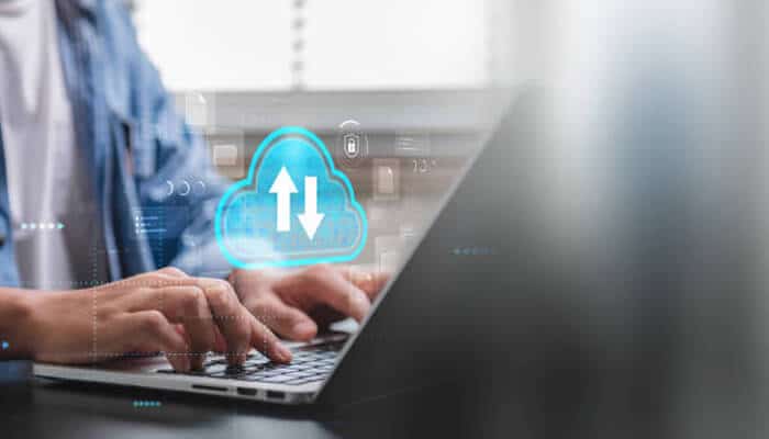 Choose highly scalable cloud architectures | tycoonstory media Advanced computer technologies applied in choosing highly scalable cloud architectures, showing a professional using a laptop with a digital cloud upload and data transfer icon representing scalable cloud computing and secure online infrastructure management.