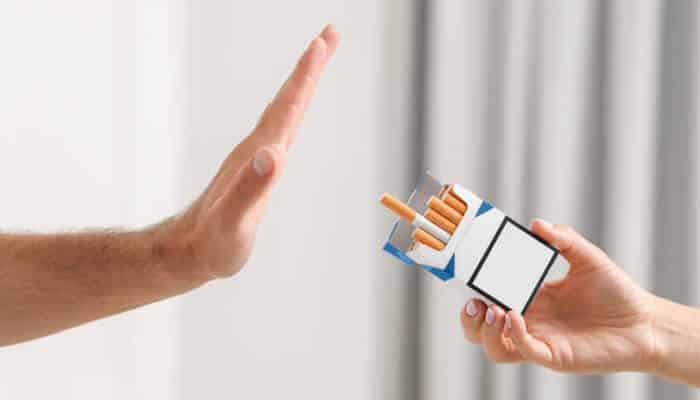 The push for smoke-free generations | tycoonstory media Person refusing a pack of cigarettes, representing smoking bans and the global push to create healthier, smoke-free generations.