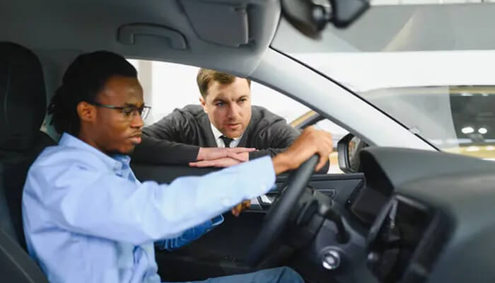 What massachusetts driver retraining actually is | tycoonstory media Massachusetts driver receiving hands-on instruction from a driving instructor inside a car, learning safe driving skills and vehicle handling.