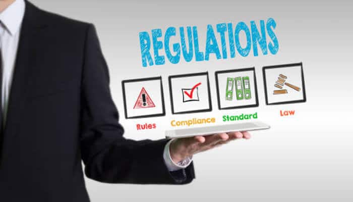 Staying aware of regulations | tycoonstory media Heating engineering business concept showing regulations, compliance, standards, and legal requirements displayed on a digital interface held by a professional, highlighting industry rules and safety compliance.