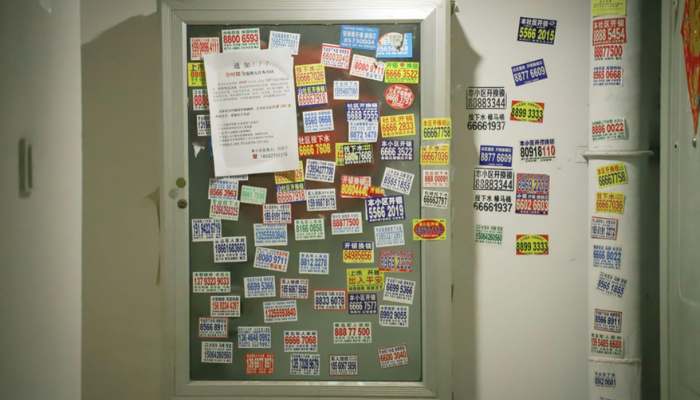 How large notice boards improve workplace communication 2 | tycoonstory media Door and walls densely covered with colorful chinese flyers and stickers, obscuring the door frame with posters of ads.