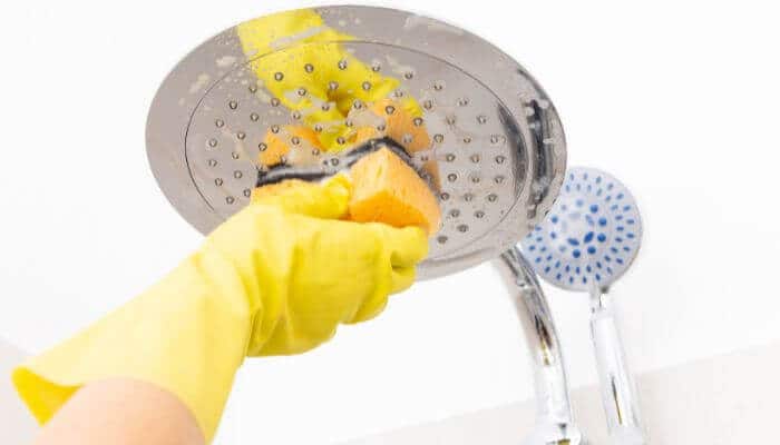 How to clean shower head vinegar 7 easy steps | tycoonstory media How to clean shower head vinegar by gently scrubbing mineral buildup from a rainfall shower head with a soft sponge during routine bathroom cleaning.