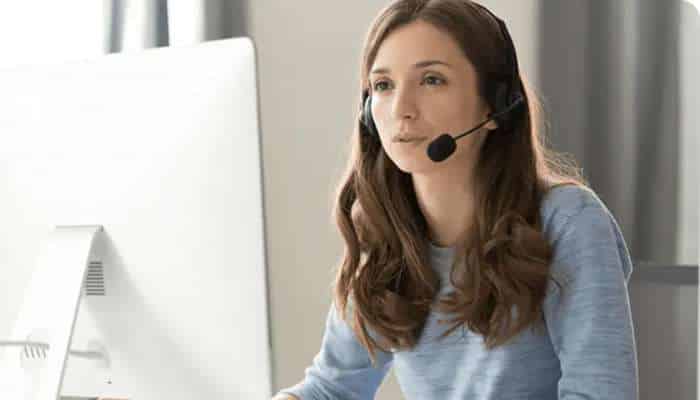 Real-time translators 1 | tycoonstory media Customer service representative wearing a headset and working at a computer.