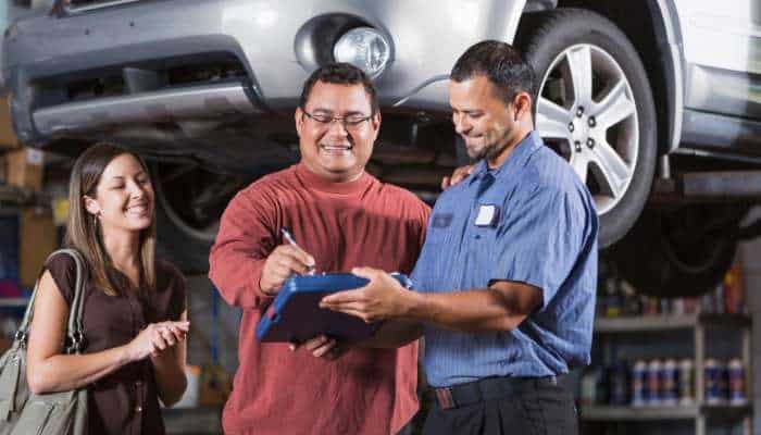 Signal garage auto care 1 | tycoonstory media Signal garage auto care technician inspecting a vehicle with customers during professional auto service and repair.