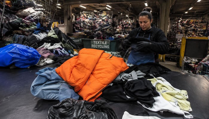 Textile and clothing recycling - tycoonstory | tycoonstory media Local recycling centers textile recycling facility with workers sorting clothing, fabrics, and donated garments in a large indoor processing warehouse