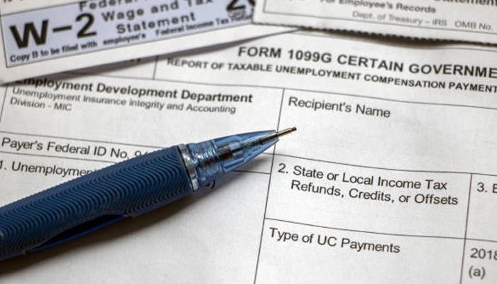 Untitled-1 | tycoonstory media Close-up of w-2 and 1099 tax forms with pen highlighting details and 1099 tax calculator used for accurate income reporting.