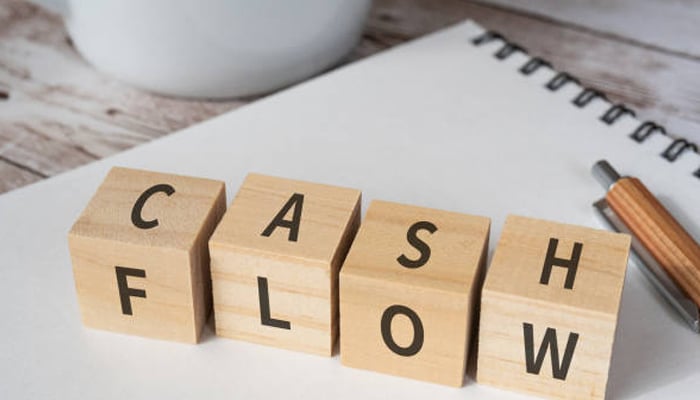 Untitled-1 | tycoonstory media Wooden blocks spelling cash flow on desk representing finance tracking and navigate capital cash flow management concepts.