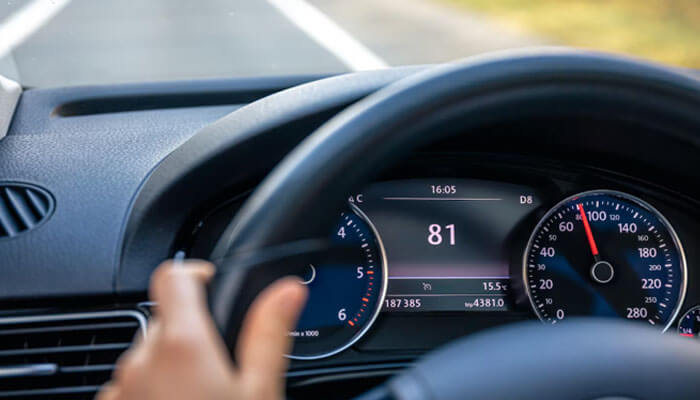 Vehicle performance gradually declines - tycoonstory | tycoonstory media Driver's hand on the steering wheel as the car’s instrument cluster shows a central speed readout of 81.
