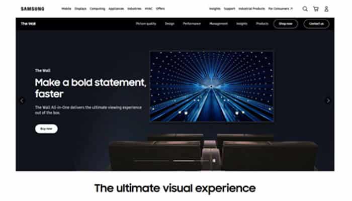Samsung electronics - tycoonstory | tycoonstory media Samsung hero image: dark living room with a large wall-mounted tv displaying a blue starburst screen and seating below, promoting a bold statement.