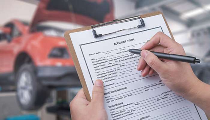 What accident victims should know about personal injury claims in texas 2 | tycoonstory media Person holding a clipboard with an accident form and pen in a repair shop, a red car in the background
