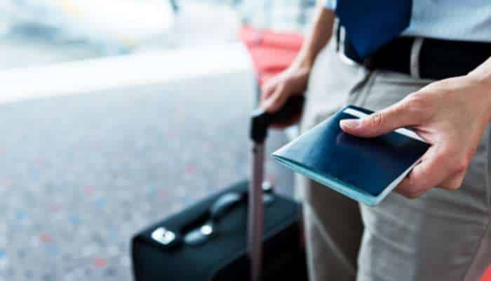 What business travellers should know before heading to houston 1 | tycoonstory media Business travellers at airport holding passport and suitcase, preparing for departure and smooth corporate travel journey.