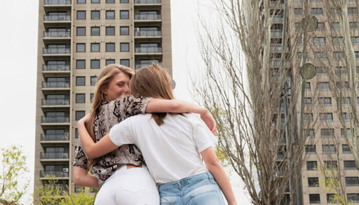 What is the typical vacancy rate for rental property in competitive markets - tycoonstory | tycoonstory media Two women hug outdoors in front of tall apartment buildings and a leafless tree, sharing a friendly moment in an urban setting.