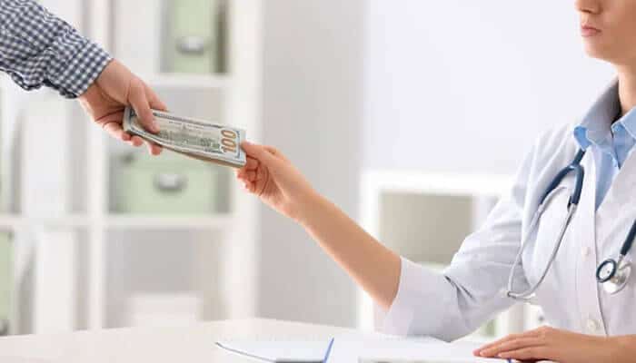 Why billers struggle with payer rules - tycoonstory | tycoonstory media Healthcare provider discussing payments with a patient, illustrating how claim denials and billing issues can impact healthcare revenue cycles.