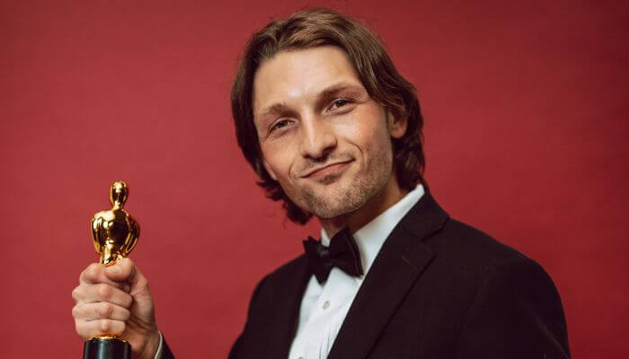 Why supporting roles are often harder than lead roles 1 | tycoonstory media Academy award for best supporting actor winner holding an oscar statuette during an awards celebration