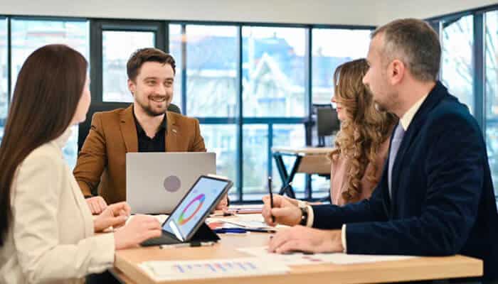Communicate with employees and clients - tycoonstory | tycoonstory media Management team discussing employee updates, client notifications, and relocation timelines during a business relocation meeting to ensure smooth communication, operational continuity, and successful office transition.