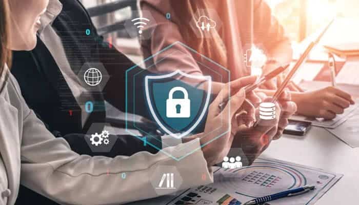 The layer startups overlook: a vpn - tycoonstory | tycoonstory media Business professionals using laptops and mobile devices with a digital security shield overlay, demonstrating data protection solutions including encryption, secure cloud access, cybersecurity, and data privacy for modern workplaces.