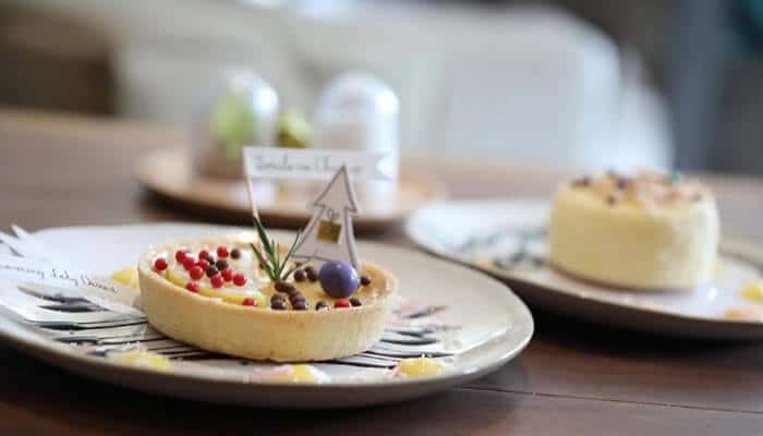 Elegant packaging supports special occasions - tycoonstory | tycoonstory media Minimalist bakery presentation featuring beautifully arranged gourmet desserts on elegant plates with soft colors, simple styling, and a refined bakery aesthetic designed for luxury celebrations.