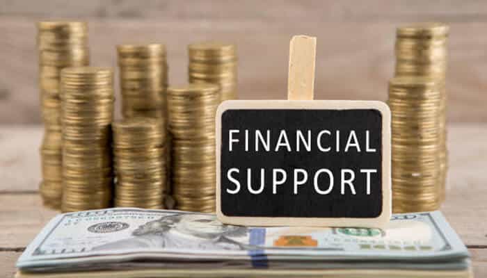 Financial support and settlement benefits after arrival | tycoonstory media Aliyah financial support benefits illustrated with stacked coins and cash, representing sal klita assistance, settlement grants, rental support, and financial aid available to new immigrants after making aliyah to israel.