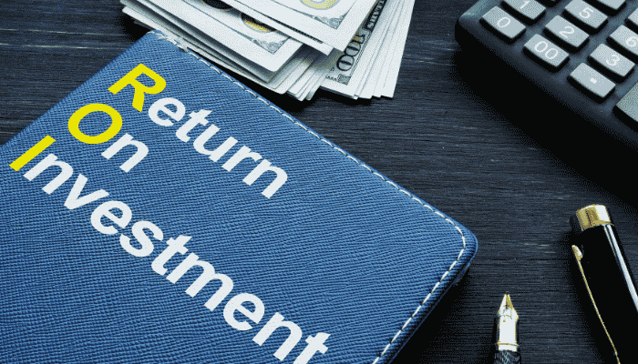 Improve software meetshaxs - tycoonstory | tycoonstory media Close-up of a notebook labeled “return on investment” next to cash, a calculator, and pen, illustrating how improve software meetshaxs enhances roi and business financial performance.