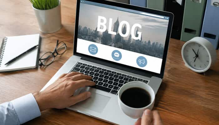 How to start blogging as a side hustle - tycoonstory | tycoonstory media Blogging as a side hustle setup with a laptop displaying a blog website on a home-office desk