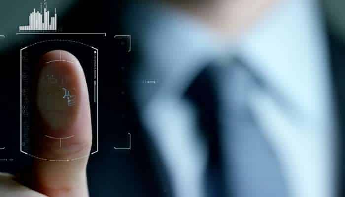 How video fingerprinting catches pirates before the damage is done 1 | tycoonstory media Close-up of a fingertip with a futuristic biometric scan interface overlay, blurring a suited figure in the background.