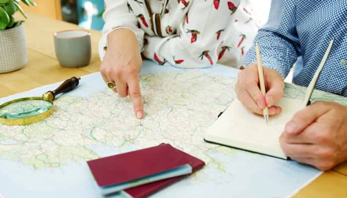 Tips for planning an irresistible regional getaway | tycoonstory media Travelers planning a regional getaway using a map, notebook, and travel tools, highlighting step-by-step trip preparation under tips for planning an irresistible regional getaway with a focus on smart and intentional travel planning.