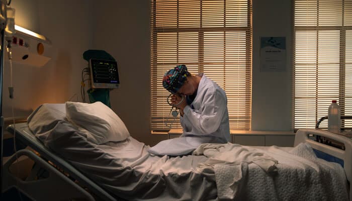 Mental-health themes - tycoonstory | tycoonstory media The housemaid parents guide image showing a hospital room with a distressed medical professional, highlighting the film's psychological trauma, psychiatric hospitalization, manipulation, and mature themes for parents.