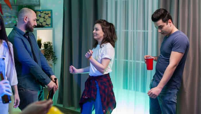 My experience with empire entertainment - tycoonstory | tycoonstory media Group of adults dancing and chatting at a casual indoor party; a man with a red cup stands nearby while others mingle and move to the music.