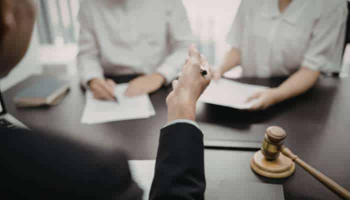 Serious injury claims in altadena encino and hollywood 2 | tycoonstory media Businesspeople in a meeting with documents on the table and a gavel in the foreground, suggesting a legal setting.