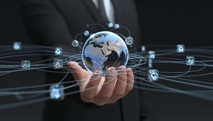 Want a smarter more connected community start with your website 1 | tycoonstory media Hand in a suit holding a globe with interconnected digital network icons around it. Edit: concise and informative for screen readers.