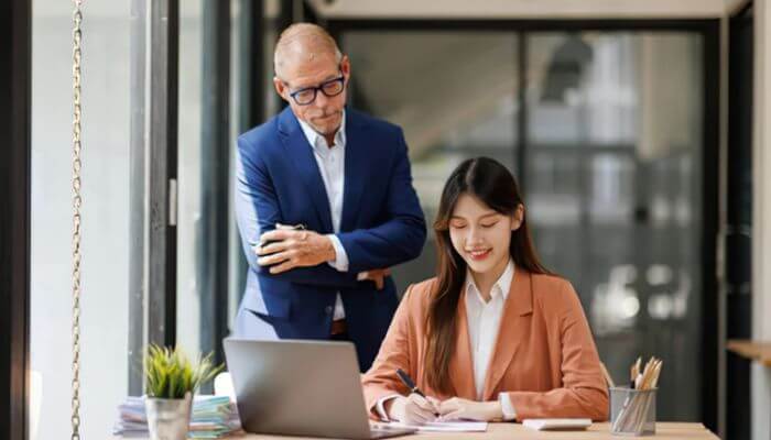 What are the benefits of having a career mentor 1 | tycoonstory media What is a career mentor? Senior professional mentoring a young employee during a career development session in a modern office.