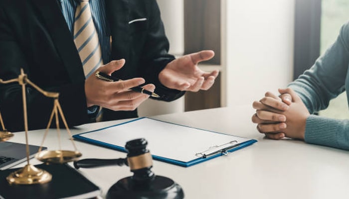 When to call a attorney | tycoonstory media Boise legal guide showing an attorney consultation with clients discussing legal documents and important decisions