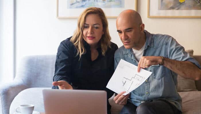 Builders are adapting to new consumer expectations - tycoonstory | tycoonstory media Future of homeownership concept featuring a couple reviewing home plans and financial decisions while adapting to modern housing market trends.