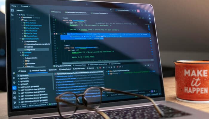 The hidden costs no one talks about - tycoonstory | tycoonstory media Software dowsstrike2045 python update displayed on a developer laptop with python-style code, debugging panels, eyeglasses, and a motivational desk mug.