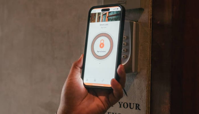 Smart lock: what renters should know before installing | tycoonstory media Smart lock being accessed with a smartphone, showing how renters can use digital controls for convenient and secure door entry.