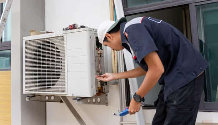 Use social media video and retargeting - tycoonstory | tycoonstory media Digital marketing for hvac companies showing a professional hvac technician repairing an outdoor air conditioning unit to improve customer trust, online visibility, and lead generation.
