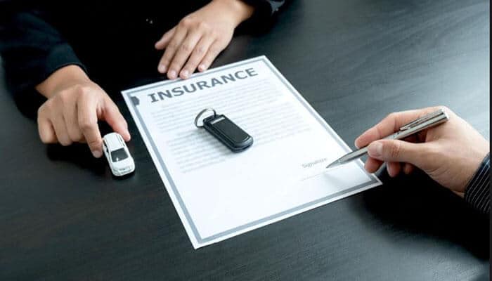 Common insurer tactics and excuses - tycoonstory | tycoonstory media Insurance paperwork and car keys being reviewed while filing a motorcycle claim for accident coverage and compensation.