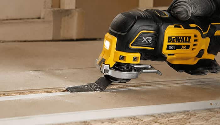 What can you cut with a dewalt oscillating multi tool - tycoonstory | tycoonstory media Dewalt oscillating multi tool with led work light and wood-cutting blade making a precise plunge cut in a wooden panel during a remodeling project.