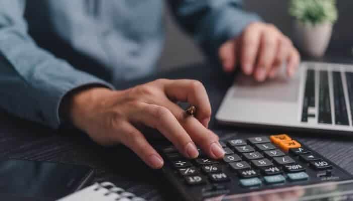 What if your expenses are higher than your income 1 | tycoonstory media What are some key components of successful budgeting? Person using a calculator and laptop to manage monthly finances
