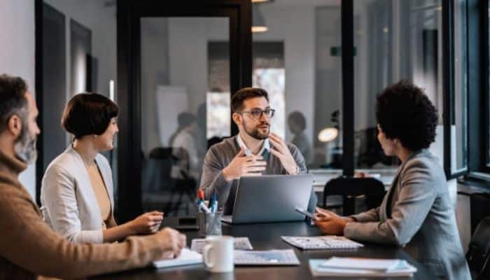 Look for clear communication | tycoonstory media Business team discussing custom ai agent development, project requirements, integrations, and implementation strategy during a meeting.