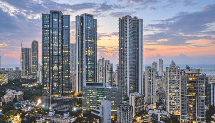 How smarter access control changes building management - tycoonstory | tycoonstory media High-rise city skyline at dusk with illuminated windows among dense urban buildings.