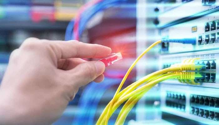 Cable quality affects the foundation | tycoonstory media Person plugging a red ethernet plug into a network switch with yellow cables nearby.